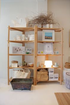 the shelves are filled with various items and things to put on them, including baskets