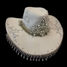 YEEHAW! Beautifully embellished with a variety of rhinestones and pearls, this hat is bound to dazzle the whole saloon! Made from a faux suede, and lined with a beautiful paisley satin, it is as beautiful on the inside as the outside!  Features rope with metal filigree ends, let them hang loose for a wide brim style hat, or tie it up on top for a western style! (see video)  Will fit up to a 60cm head circumference  Also available in other colours and styles. DM for any enquiries 🖤🐎 Note: same Cheap Hat Bands For Western-themed Events, Custom Cowgirl Hats With Rhinestones, Hat With Rhinestone Fringe, Festival Hat With Rhinestones And High Crown, Festival Hats With Rhinestones And High Crown, Elegant Embellished Hats For Festival, Elegant Rhinestone Hats For Festival, Elegant Rhinestone Festival Hats, Boho 2024