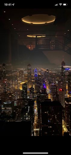 an aerial view of the city at night with lights on and skyscrapers lit up