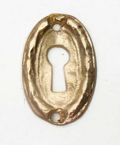 an antique brass keyhole on a white background