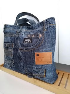 a bag made out of jeans with a leather tag on the front and back pocket