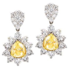 These beautiful earrings contain 2 gorgeous pear cut Yellow Diamonds totaling 2.2 carats which are surrounded by VS2, G color diamonds in a halo around the yellow diamond as well as a diamond cluster on top. There are 38 round diamonds totaling 2.2 carats. These earrings have a postback which makes them easy, comfortable, and secure to wear. The stones are set in 18 karat white gold. Yellow Diamonds, Diamond Drops, Diamond Drop Earrings, Lovely Jewellery, Yellow Diamond, Diamond Cluster, 2 Carat, Pear Cut, White Diamonds