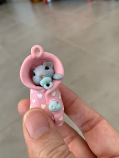 a tiny teddy bear in a pink heart - shaped tube with hearts on it's side