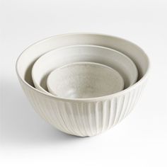 three white bowls sitting on top of each other in front of a white background,