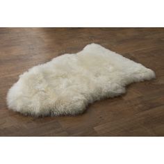 a white sheepskin rug laying on top of a wooden floor