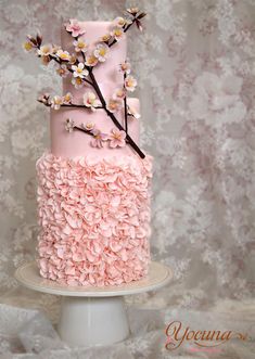 a pink wedding cake with white flowers on the top and bottom, is displayed in an instagram