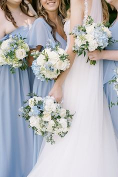 the bride and her bridesmaids are all dressed in blue dresses with white flowers