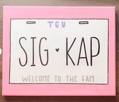 a pink and white license plate with the word big kap written in black on it