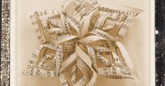 an old photo with sheet music in the shape of a flower made out of sheet music