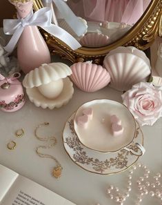 a table topped with pink and white items next to a mirror