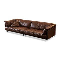 a brown leather couch sitting on top of a white floor