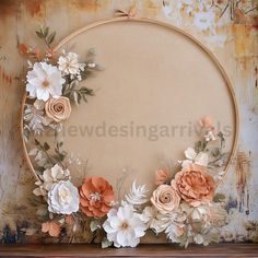 an oval frame with flowers and leaves is on the wall in front of a rusted background