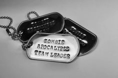 two dog tags with the words zombie apocalypse team leader on them hanging from a chain