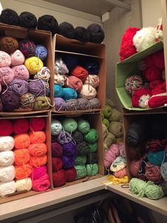 there are many balls of yarn on the shelves