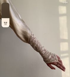 a woman's arm with lace on it and her hand in the other direction