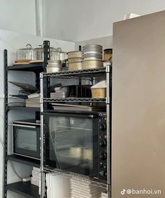 an oven and microwave in a kitchen with shelves full of pots, pans, and other items