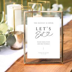 a wooden table topped with a sign and candles