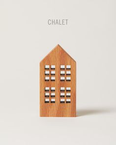 a small wooden house sitting on top of a white surface with the words chalet above it