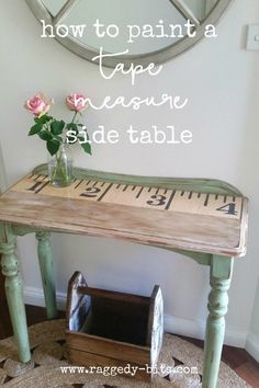 a wooden table with tape measure on it and flowers in a vase next to it