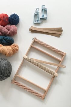 several skeins of yarn are sitting on a table next to some knitting needles