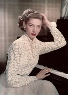 a woman sitting at a piano with her hands on her head and looking off to the side