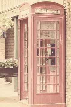 an old fashioned red telephone booth on the street