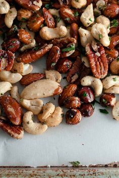 nuts and cashews are scattered on a piece of parchment paper