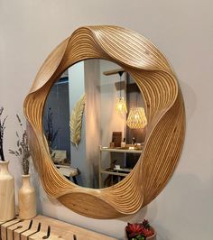 a mirror that is sitting on top of a shelf next to a vase and flowers