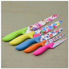 five colorful plastic utensils lined up on a table