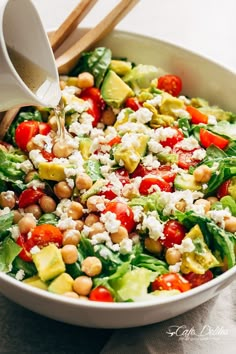 a salad with chickpeas, tomatoes, avocado and feta cheese