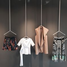 three different types of clothes hanging on hooks