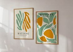 two framed posters on the wall next to each other, one with an orange and green flower design