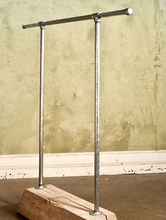 a pair of metal poles sitting on top of a cement floor next to a wall