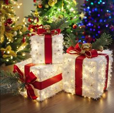 three presents are wrapped in red and white ribbon with bows on them, sitting next to christmas trees