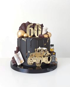 a birthday cake decorated with chocolate and gold decorations, including a truck on the top