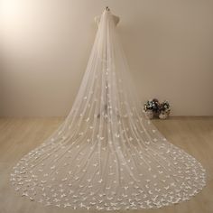 a wedding veil with white flowers on it