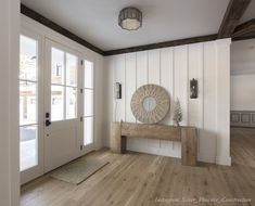 a wooden bench sitting in front of a door on top of a hard wood floor