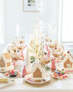 a table set for christmas with gingerbread houses