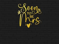 the phrase soon to be mrs on a black brick wall with gold foil lettering and hearts