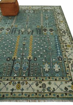 a blue rug with an intricate design on the middle, and a wooden footstool