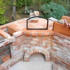 an outdoor brick pizza oven built into the side of a building with bricks around it