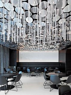 a room with chairs, tables and chandelier hanging from it's ceiling