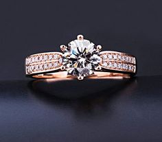 an engagement ring with two rows of diamonds on top of it and the center stone in the middle