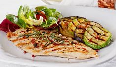 grilled fish and vegetables on a white plate