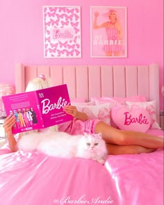 a woman laying in bed reading a book with a white cat on her lap next to her