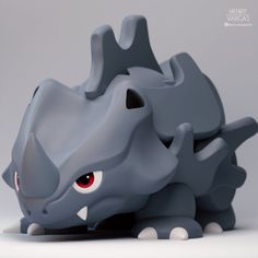 a gray toy with red eyes is laying on the ground