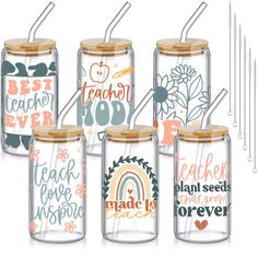 four glass jars with different designs and words on the lids, one has straws in it