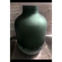 a large green vase sitting on top of a table