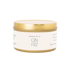 gin fizz candle in a tin with gold lid and label on the front, against a white background