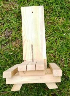 a piece of wood sitting on top of green grass next to a wooden object in the shape of a chair